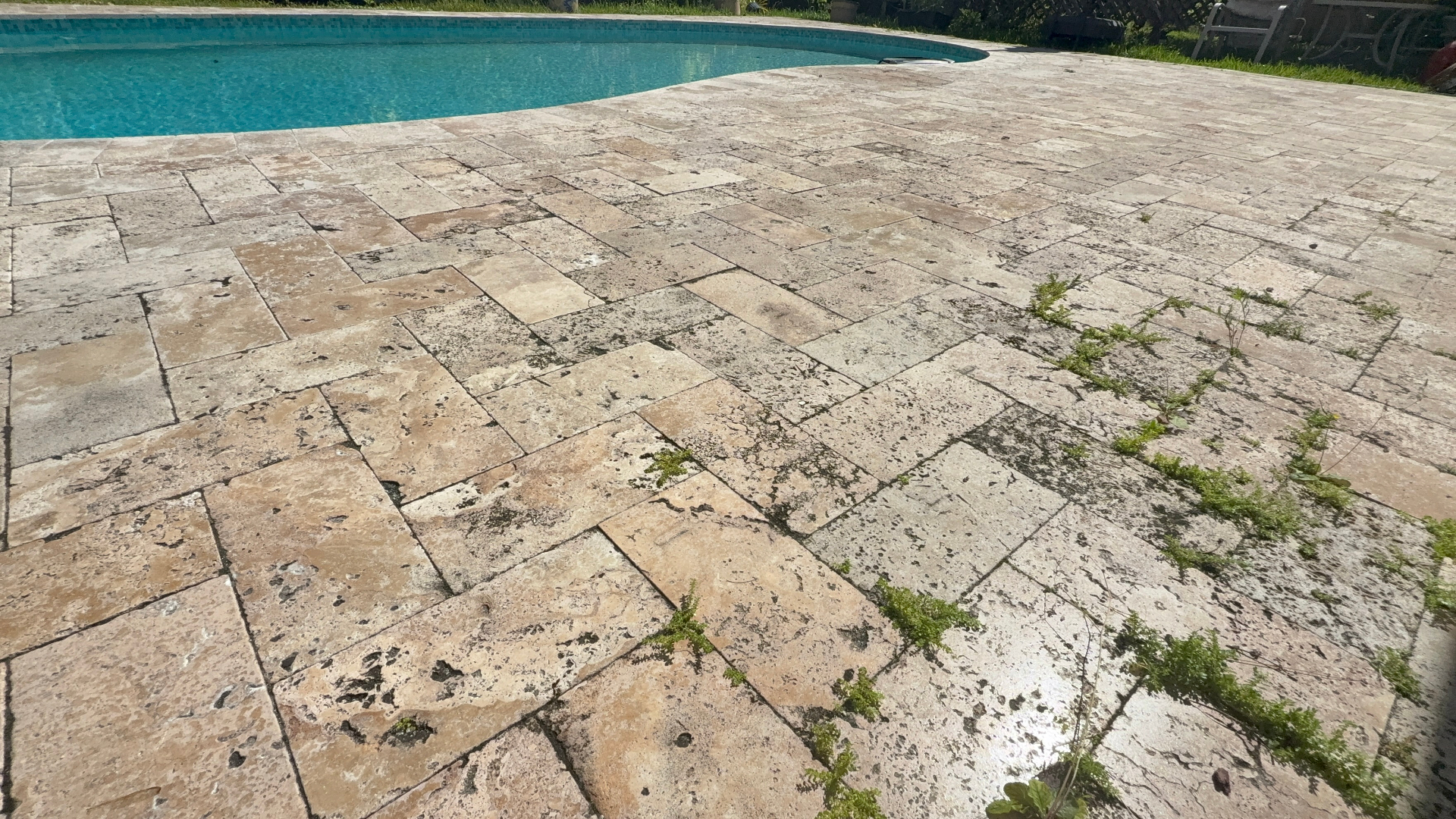 Travertine pool deck cleaned and sealed by Patty's Sealing — before