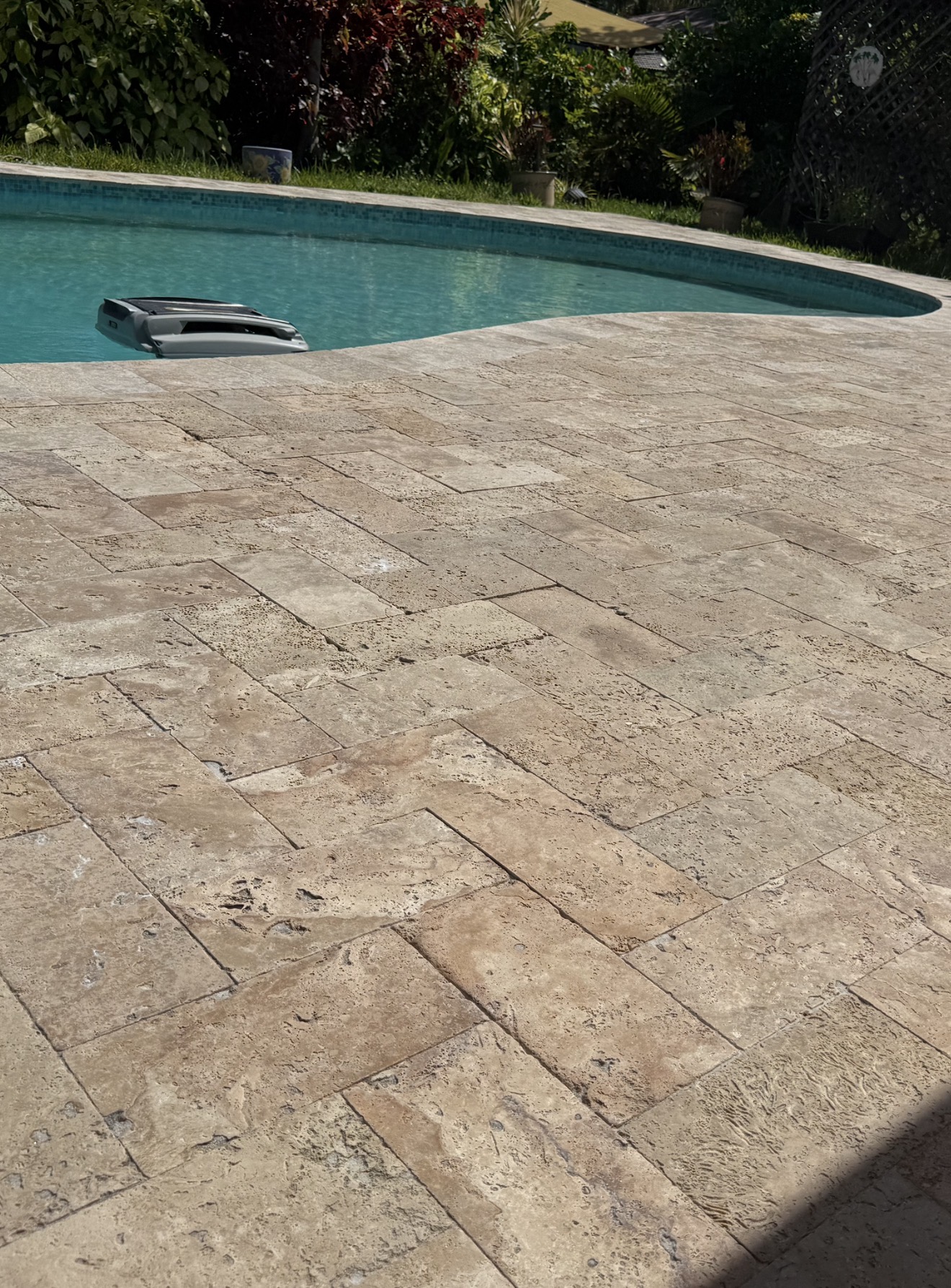 Freshly sealed travertine pool deck with rich, even color